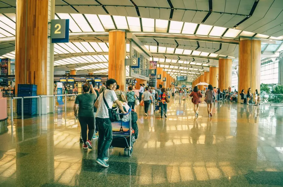 Travelers standing and walking through a busy airport terminal