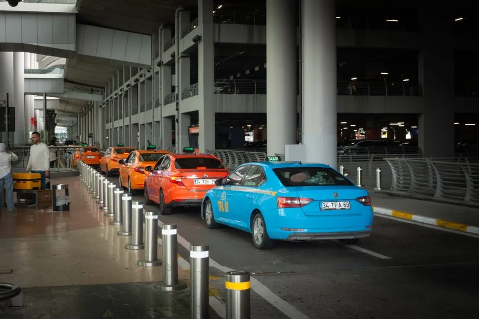 Line of taxis queued at an airport arrivals curb
