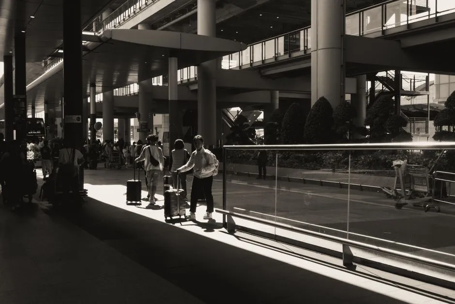 Travelers with luggage walking through a modern airport terminal concourse